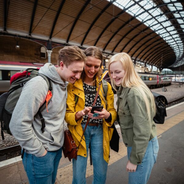 Travel and Technology - Friends using a phone while on their trip